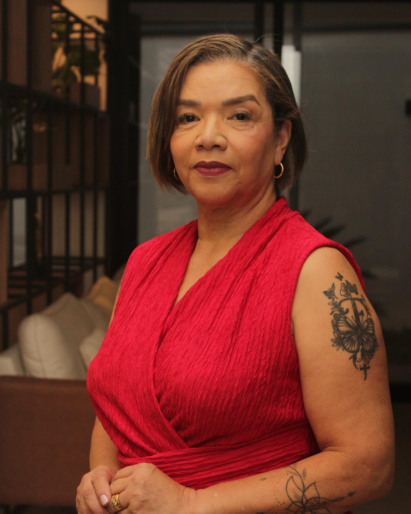 Dra. Neuza Santos em retrato de vermelho, fundo escuro